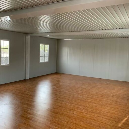 Modern two-story container home with balcony and large windows.