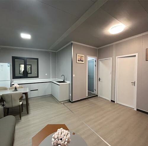 Modern living room with kitchen area, dining table, and decor.